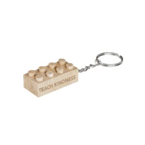 Timber Brands engraved wooden 2x4 brick keychain featuring the phrase Teach Kindness, compatible with plastic brick systems