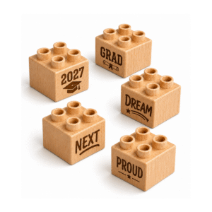 Set of five custom engraved wooden Plus bricks with graduation word designs including "2027," "Grad," "Next," "Dream," and "Proud"