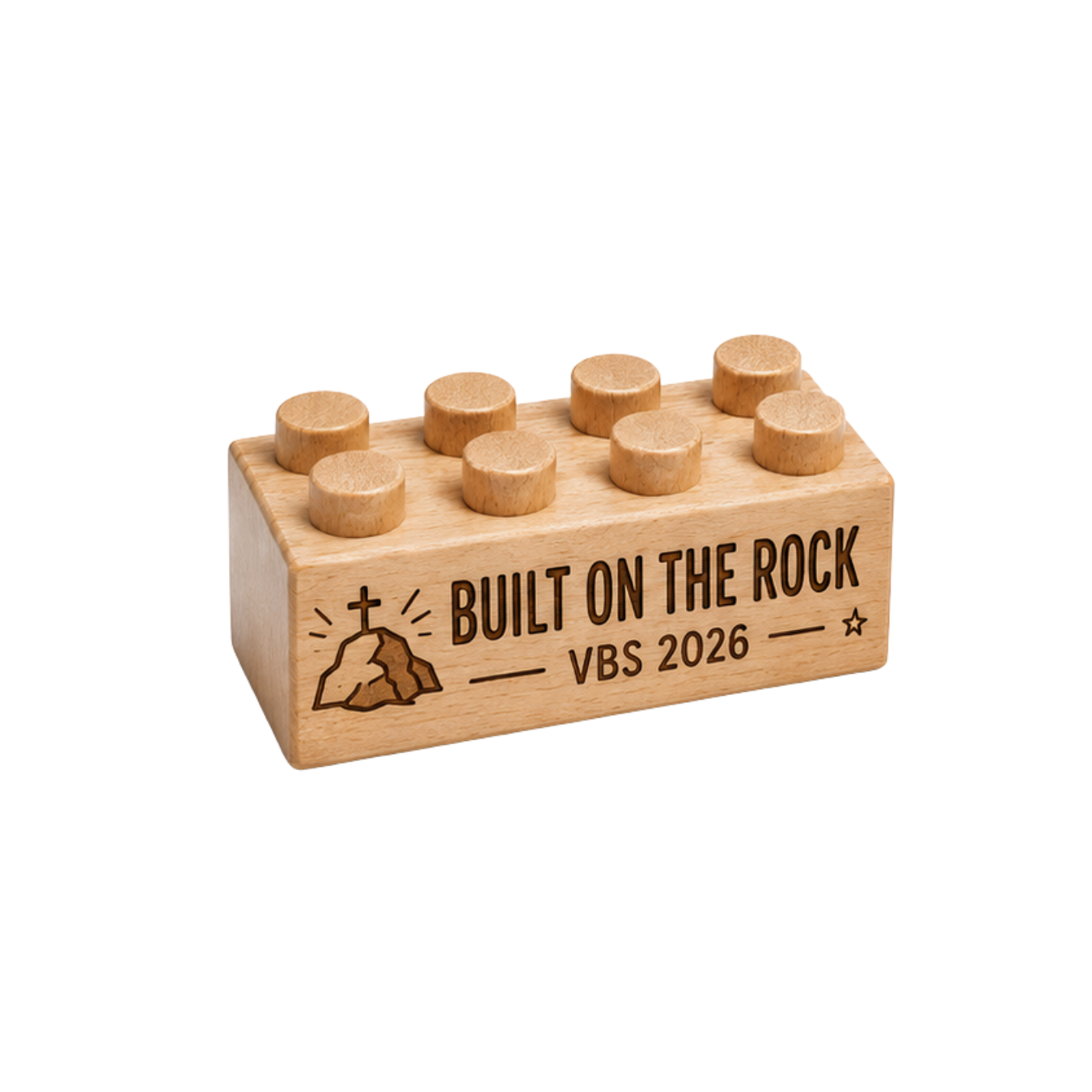 Wooden brick engraved with Built on the Rock and VBS 2026, with a cross on a rock and stars.