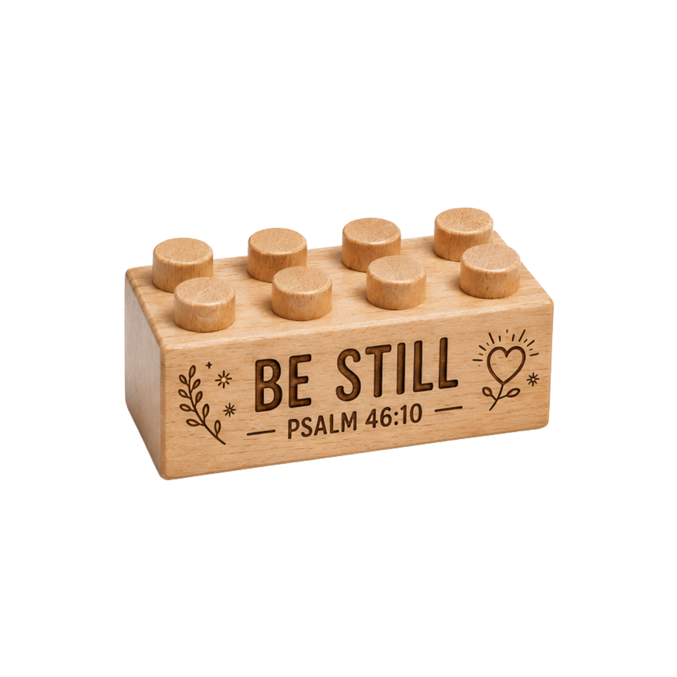 Wooden brick engraved with Be Still and Psalm 46:10, with a heart, leaves, and small stars.
