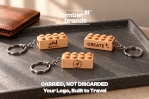 Engraved wooden brick keychains reading "North," "Create," and a compass icon on keyring hardware for custom logo keychains.
