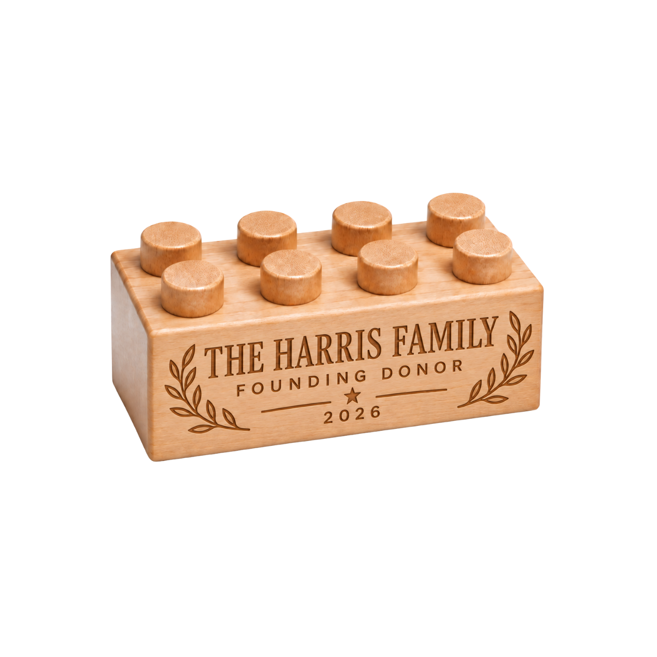 Wooden brick engraved with The Harris Family, Founding Donor, and 2026, framed by laurel branches.