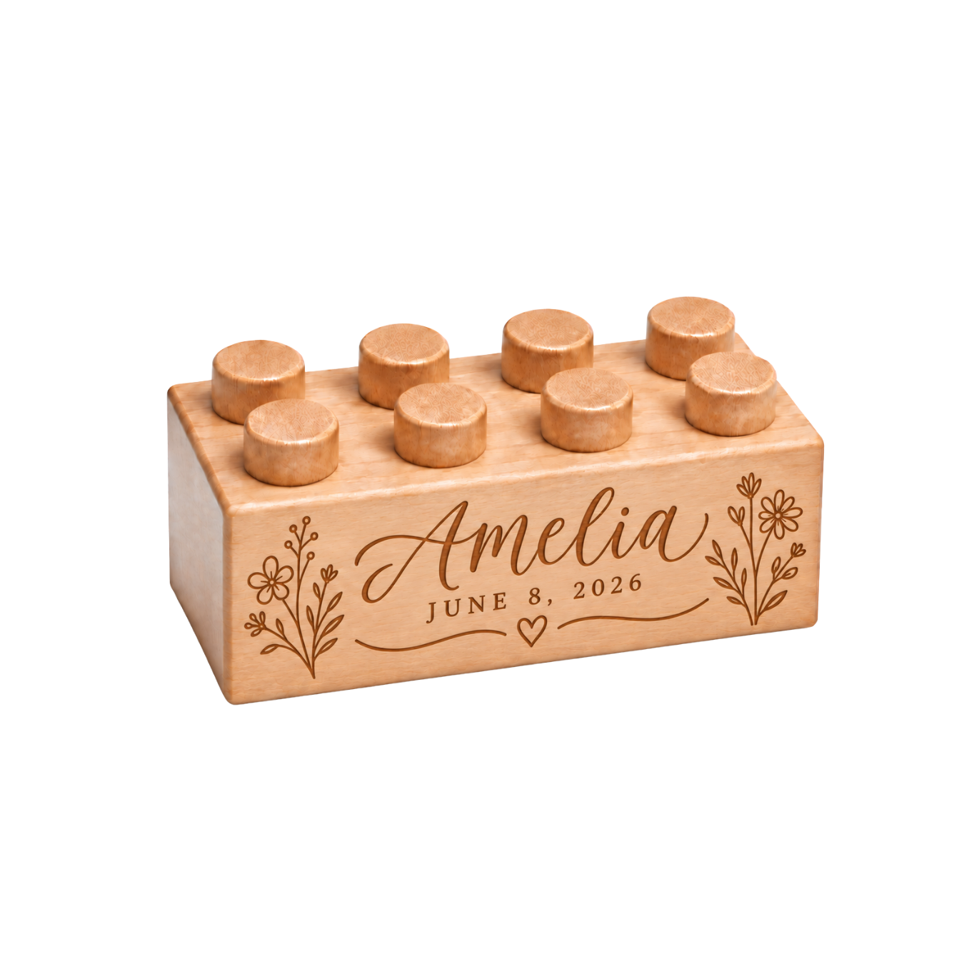 Wooden brick engraved with Amelia and June 8, 2026, framed by floral sprigs and a small heart.