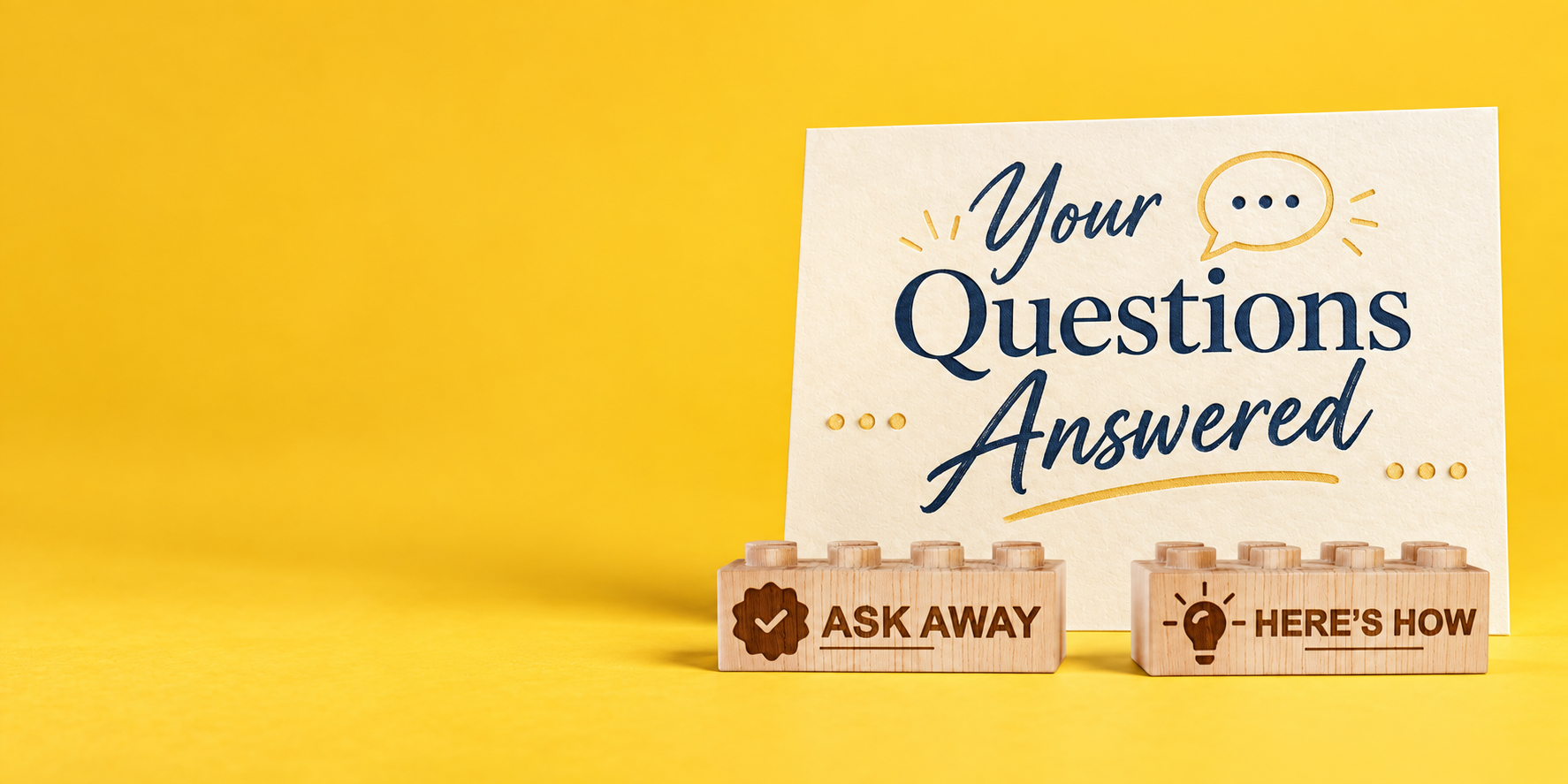 Wooden bricks engraved with Ask Away and Here’s How in front of a Your Questions Answered sign on a yellow background.