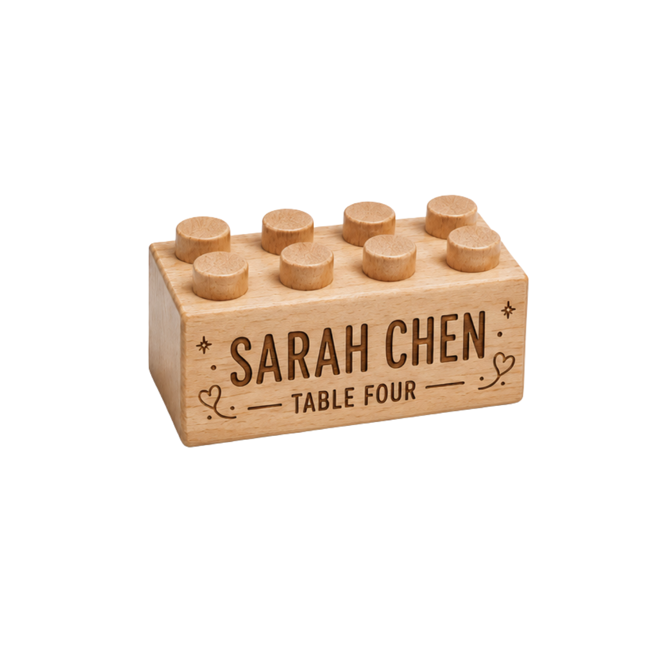 Wooden brick place card engraved with Sarah Chen and Table Four, with heart and star details.